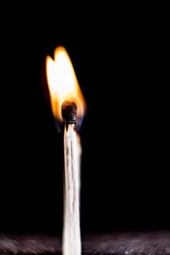 Burning match, on a black background Stock Photos