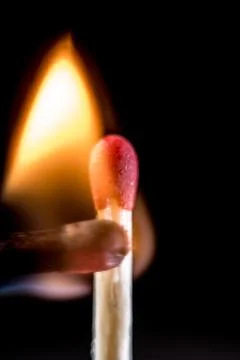 Burning match, on a black background Stock Photos