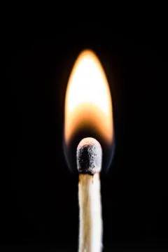 Burning match, on a black background Stock Photos