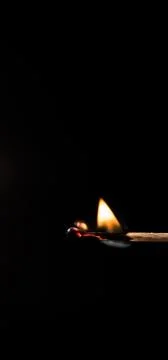 Burning match, on a black background Stock Photos