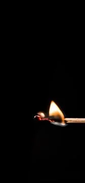 Burning match, on a black background Stock Photos