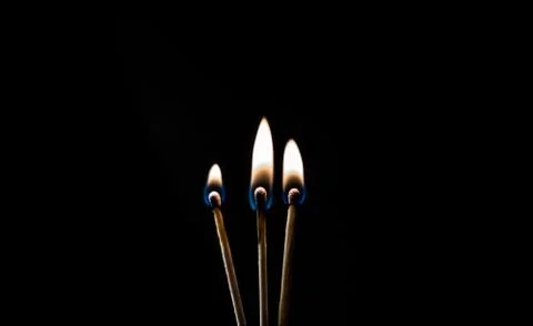 Burning match, on a black background Stock Photos
