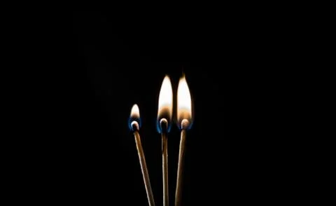 Burning match, on a black background Stock Photos
