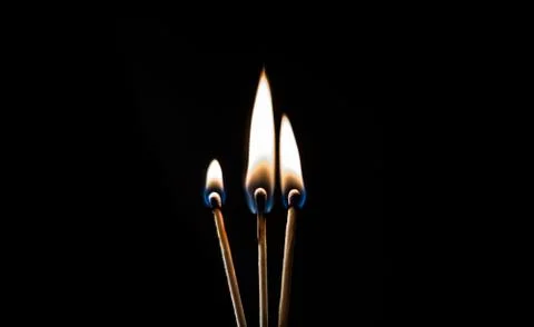 Burning match, on a black background Stock Photos