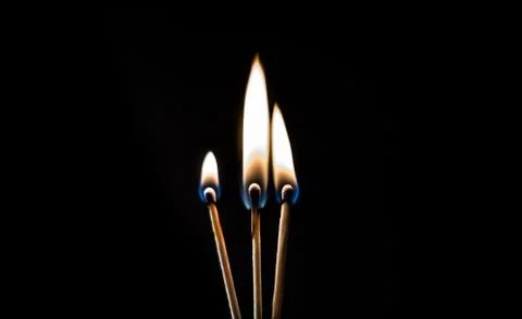 Burning match, on a black background Stock Photos