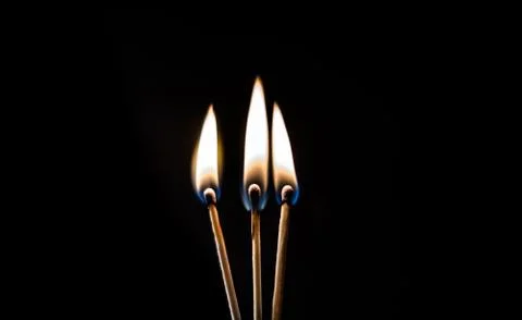 Burning match, on a black background Stock Photos