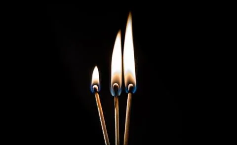 Burning match, on a black background Stock Photos
