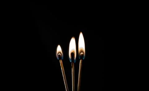 Burning match, on a black background Stock Photos