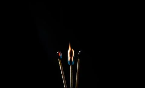 Burning match, on a black background Stock Photos