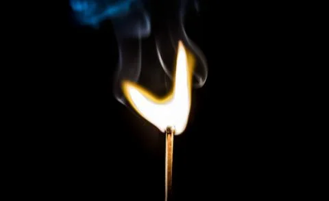Burning match, on a black background Stock Photos