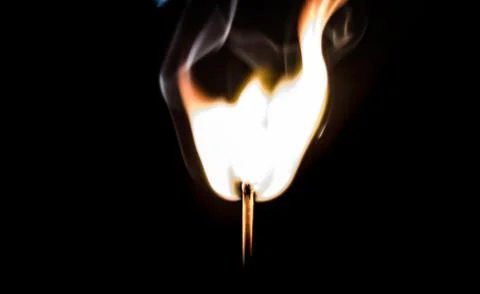 Burning match, on a black background Stock Photos
