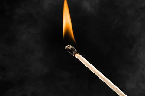 Burning match on black background Stock Photos