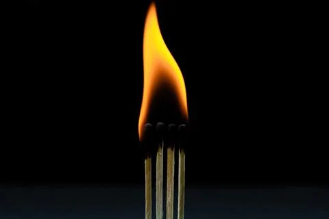 Burning match on a black background. Several matches are burning against a dark  Stock Photos