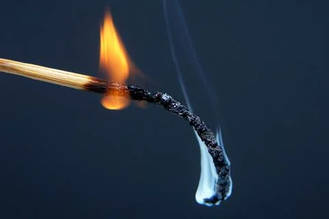 Burning match on a dark background Stock Photos