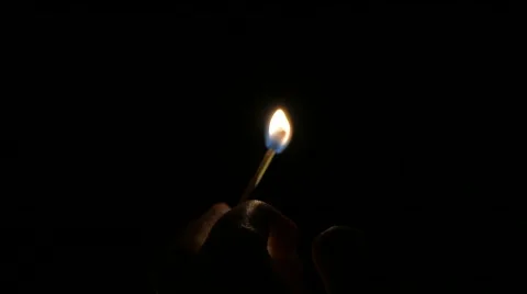 Burning match in hand on black background, 4k Stock Footage 60744007