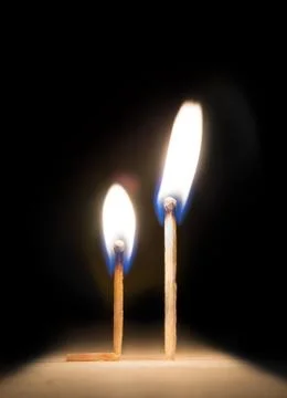Burning match kneeling before match on fire metaphor Stock Photos