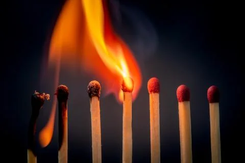 Burning match setting fire to its neighbors Foto stock