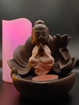 Burning multi-colored candles and a figurine Stock Photos