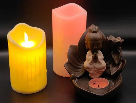 Burning multi-colored candles and a figurine romantically Stock-Fotos