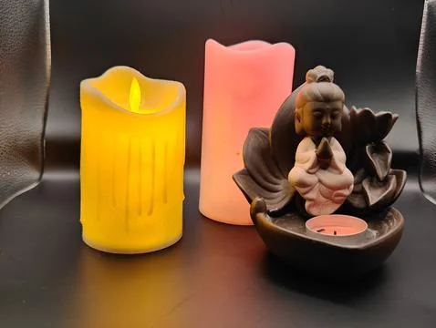 Burning multi-colored candles and a figurine romantic setting Stock Photos