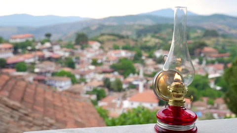 Burning oil lamp with rack focus to historic Sirince village landscape Stock Footage 336053472