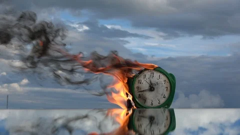 Burning old alarm clock on sky background, slow motion 스톡 동영상 104330182