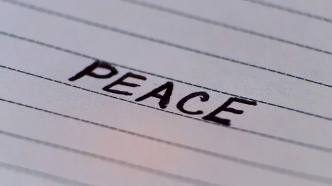 Burning paper on which is written "PEACE". Macro video Stock Footage 84750792