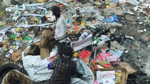 Burning pile of garbage at dump ground. Sanitation Workers segregating garbage Stock-Fotos