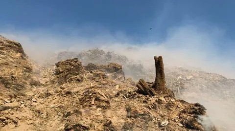 Burning pile of garbage at dump ground or landfill releasing toxic smoke Stock-Fotos