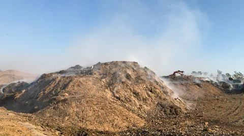 Burning pile of garbage at dump ground or landfill releasing toxic smoke Stock-Fotos