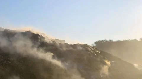 Burning pile of garbage at dump ground or landfill releasing toxic smoke Stock-Fotos