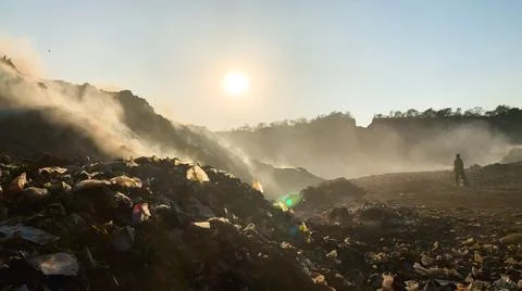 Burning pile of garbage at dump ground. Sanitation Workers segregating garbage Stock-Fotos