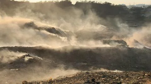 Burning pile of garbage at dump ground or landfill releasing toxic smoke 스톡 사진
