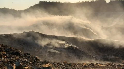 Burning pile of garbage at dump ground. Sanitation Workers segregating garbage Fotos de archivo