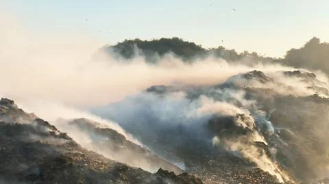Burning pile of garbage at dump ground or landfill releasing toxic smoke Fotos de archivo
