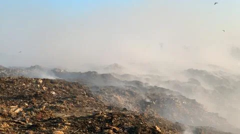 Burning pile of garbage at dump ground or landfill releasing toxic smoke Stock-Fotos