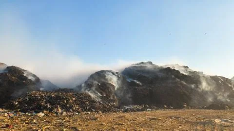 Burning pile of garbage at dump ground or landfill releasing toxic smoke Stock-Fotos