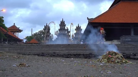 A burning pile of litter on the beach in front of Hindu Temple Stock Footage 74289522