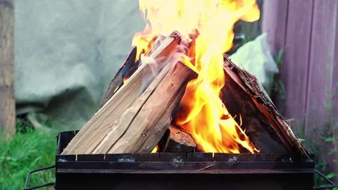 Burning pine logs for coals. Strong flame on the grill. Burning firewood on the Stock Footage 230721837