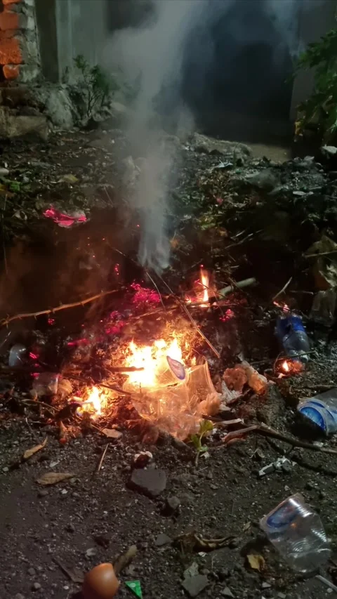 Burning plastic and paper waste on the ground with fire smoke Stock Footage 277936153