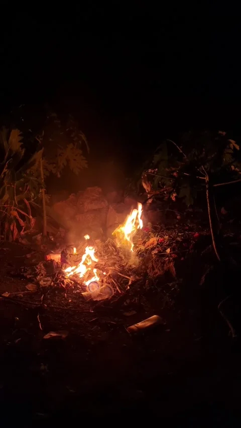 Burning plastic and paper waste on the ground with fire smoke Stock Footage 277936154