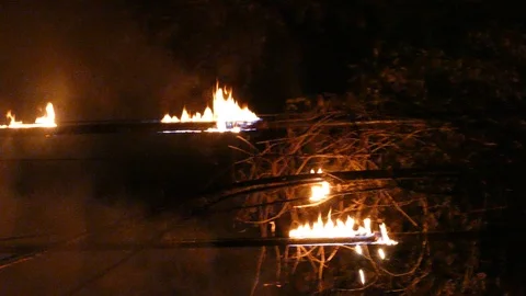 Burning power cables at night lets drops of liquified plastic fall from wires on Stock Footage 94908924