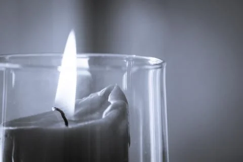 Burning red candle inside a clear glass vase Foto stock