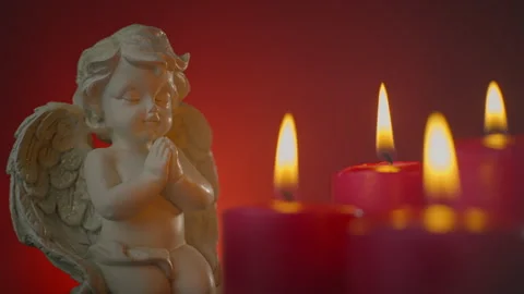 Burning red candles and a praying angel on a red background. Stock Footage 295155003