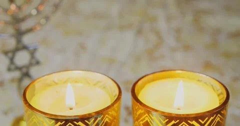 Burning Shabbat candles on the table next to the menorah. Medium plan Stock Footage 256174006