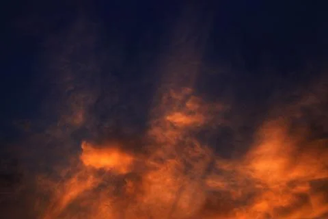 Burning sky, dramatic red colour clouds and sun ray shining through the heave Stock Photos
