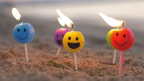 Burning smiley candles on the beach Stock Footage 72296318