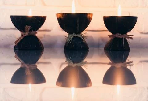 Burning spa aroma candles in coconut shell on a glass white table, cozy home  Stock Photos