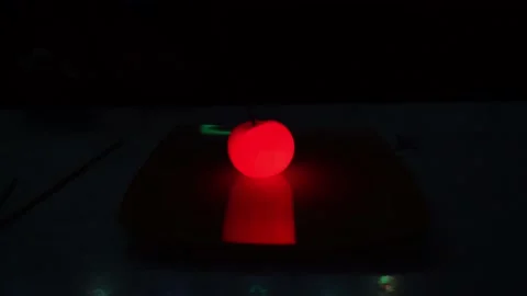 A burning sparkler inside a glowing tomato. Video stock 237922477