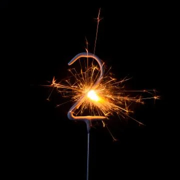 Burning sparkler in shape of number two, digit 2, isolated on black backgroun Foto stock